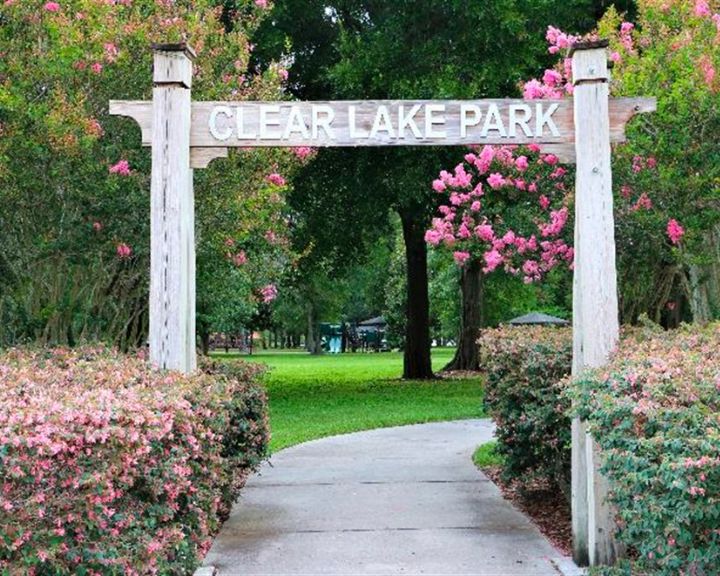 The entrance to Clear Lake Park is surrounded by pink bushes in service areas.