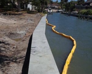 A concrete seawall is under construction next to a body of water.