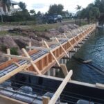 A concrete retaining seawall is being built in the water