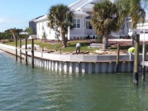 A seawall contractor is working on a dock constructing a new seawall in the water.