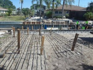A concrete foundation is being built in a yard in preparation for a new boat dock and seawall.