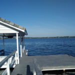 A new custom boat dock installation with a white gazebo on the water.