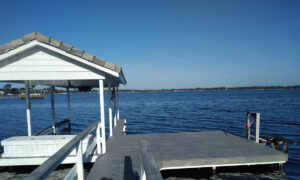 A new custom boat dock installation with a white gazebo on the water.
