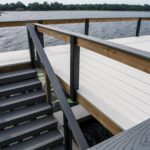 A wooden deck with stairs leading to a body of water.