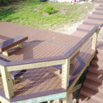 A wooden deck with a bench and stairs.
