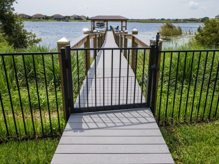 A wooden deck leading to a lake with a gate, featuring Orlando seawalls.