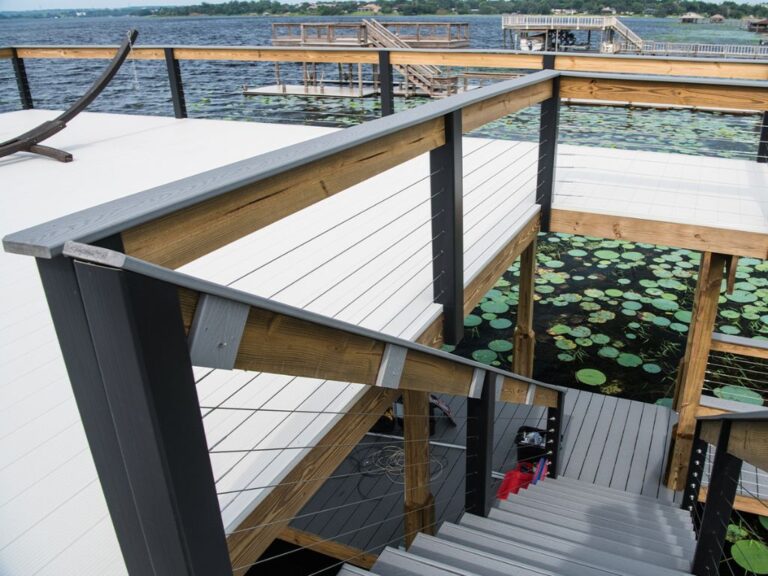 A wooden deck overlooking a serene pond adorned with blooming water lilies, accessed by a charming stairway.